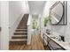 Bright entryway features hardwood floors, stairway, and a stylish table with decorative mirror at 118 I K Beatty St, Charlotte, NC 28214