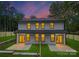 Two-story home featuring a well-maintained lawn, rear patios, and a lovely twilight sky at 118 I K Beatty St, Charlotte, NC 28214