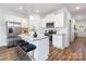 Open-concept kitchen with granite island, stainless appliances, and breakfast bar seating for three at 118 I K Beatty St, Charlotte, NC 28214