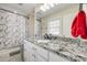 Bathroom with a granite countertop, modern sink, and marble-patterned shower with a white and gray color scheme at 1218 Calhoun St, Rock Hill, SC 29732