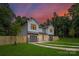 Beautiful home exterior featuring gray siding, stone accents, a well-manicured lawn, and a colorful sunset at 122 I K Beatty St, Charlotte, NC 28214