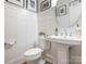 Clean bathroom with a pedestal sink, toilet, and white wainscoting at 14543 Crosswater Ln, Charlotte, NC 28278