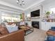 Spacious living room with a fireplace, built-in shelving, and large windows at 14543 Crosswater Ln, Charlotte, NC 28278