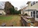 Spacious backyard with lush green grass, a wooden deck, a patio table, and a well-maintained wooden fence at 15313 Wedgewood Commons Dr, Charlotte, NC 28277