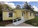 Ranch style home with yellow siding, a ramp, and a large yard at 1704 Rice Planters Rd, Charlotte, NC 28273