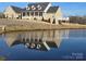Beautiful brick home featuring a tranquil pond reflecting the house at 2510 Lentz Rd, China Grove, NC 28023