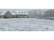 Charming brick home in winter with a welcoming porch, snow-covered yard, and picturesque pond at 2510 Lentz Rd, China Grove, NC 28023