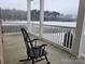 Cozy covered porch with a rocking chair offering a tranquil view of the snow-covered landscape and water at 2510 Lentz Rd, China Grove, NC 28023