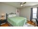 Cozy bedroom with green bedding, hardwood floors, and ceiling fan at 2510 Oakboro Ln, Charlotte, NC 28214