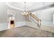 Formal dining room with a tray ceiling, carpet flooring, and decorative molding, adjacent to the staircase at 3323 Darlington Rd, Matthews, NC 28105