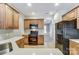 Modern kitchen featuring wood cabinets and black appliances at 3323 Darlington Rd, Matthews, NC 28105