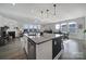 Open-concept kitchen with a large island featuring granite countertops, stainless steel dishwasher, and pendant lighting at 343 Embers Ln, Clover, SC 29710
