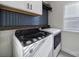 Laundry room features modern washer and dryer, updated blue tile backsplash and above storage cabinets at 343 Embers Ln, Clover, SC 29710