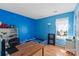 Bright blue bedroom features a desk, hardwood floors, and a twin bed with a window view at 3507 Southern Ginger Dr, Indian Trail, NC 28079