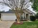 Inviting one-story home with a well-manicured lawn and a large tree in the front yard at 3507 Southern Ginger Dr, Indian Trail, NC 28079