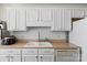 Galley kitchen with white cabinets, tile backsplash, stainless steel appliances and light countertops at 3507 Southern Ginger Dr, Indian Trail, NC 28079