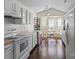 Bright eat-in kitchen featuring white cabinets, hardwood floors, and a cozy breakfast nook with a bay window at 3507 Southern Ginger Dr, Indian Trail, NC 28079