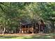 Exterior view of a charming cabin nestled among trees, with a inviting wooden porch at 3804 Putters Ln, Maiden, NC 28650