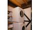 Laundry area with a stacked washer and dryer, complemented by rustic wooden shelving at 3804 Putters Ln, Maiden, NC 28650