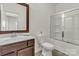 Bright bathroom featuring a brown vanity, toilet, and shower with a sliding glass door at 5051 Arbordale Way, Mount Holly, NC 28120