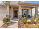 Inviting covered porch features stone pillars, seating, and decorative landscaping at front entrance at 5051 Arbordale Way, Mount Holly, NC 28120