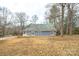 This backyard features a well-maintained lawn, a covered porch, and mature trees at 622 Oakdale Dr, Statesville, NC 28677