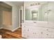 Bathroom boasts a large mirror, white vanity, tub and wood-look flooring at 622 Oakdale Dr, Statesville, NC 28677