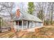 This is a charming home with a brick chimney, gray siding, and a covered front porch at 622 Oakdale Dr, Statesville, NC 28677