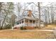 Charming blue home with a brick foundation and wraparound porch surrounded by mature trees at 622 Oakdale Dr, Statesville, NC 28677