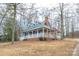 Charming blue home with a brick foundation and wraparound porch surrounded by mature trees at 622 Oakdale Dr, Statesville, NC 28677