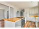 Open kitchen boasts wood countertops, stainless steel appliances, white cabinets, and an island cooktop at 622 Oakdale Dr, Statesville, NC 28677