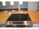 Close-up of a flat-top stove, custom countertops, with a view of the living area at 622 Oakdale Dr, Statesville, NC 28677