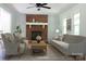 Staged living room featuring a brick fireplace, seating arrangement, and cozy decor at 622 Oakdale Dr, Statesville, NC 28677
