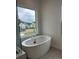 Luxurious bathroom featuring a modern tub and a large window with neighborhood views at 7120 Wayfarer Dr # 0079, Charlotte, NC 28269