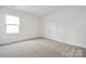 Bright bedroom featuring neutral carpet, white walls, natural light, and double doors at 7120 Wayfarer Dr # 0079, Charlotte, NC 28269