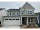 Charming two-story home with gray siding, stone accents, and a two-car garage at 7120 Wayfarer Dr # 0079, Charlotte, NC 28269