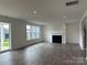 Open-concept living room with sliding doors to yard, fireplace, and wood floors at 7120 Wayfarer Dr # 0079, Charlotte, NC 28269