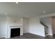 Bright, open-concept living room with a fireplace and staircase at 7120 Wayfarer Dr # 0079, Charlotte, NC 28269