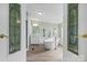 Elegant bathroom features a soaking tub with a stand faucet, vanity with mirrors, and decorative glass doors at 760 Tomlin Mill Rd, Statesville, NC 28625
