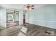 Bright bedroom featuring wood-look flooring, a ceiling fan, and mirrored closet doors reflecting an adjoined bathroom at 760 Tomlin Mill Rd, Statesville, NC 28625