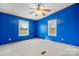 A blue bedroom featuring two windows for natural light and a ceiling fan for comfortable living at 760 Tomlin Mill Rd, Statesville, NC 28625