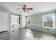This bedroom features calming green walls, two windows, and a ceiling fan with an attached bathroom featuring a soaking tub at 760 Tomlin Mill Rd, Statesville, NC 28625