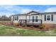 Charming home featuring a cozy front porch and fresh landscaping at 760 Tomlin Mill Rd, Statesville, NC 28625