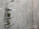 Modern tiled shower with a handheld shower head, shelving, and decorative accents at 971 Westmere Ave, Charlotte, NC 28208