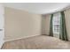 Bedroom boasting a large window with green curtains, neutral walls, and cozy carpeting at 1027 Fountainbrook Dr, Indian Trail, NC 28079