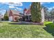 A portion of a well-maintained lawn, lush landscaping, and brick home's side at 1027 Fountainbrook Dr, Indian Trail, NC 28079