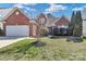 Charming brick home featuring a well-manicured lawn and attached two-car garage at 1027 Fountainbrook Dr, Indian Trail, NC 28079