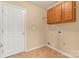 A functional laundry room with tiled flooring, cabinets, and space for washer/dryer hookups at 1027 Fountainbrook Dr, Indian Trail, NC 28079