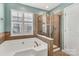 Main bathroom featuring a tile shower, large garden tub, and tiled walls at 1027 Fountainbrook Dr, Indian Trail, NC 28079