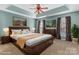 Staged main bedroom with a tray ceiling, ceiling fan, carpet, and large windows at 1027 Fountainbrook Dr, Indian Trail, NC 28079